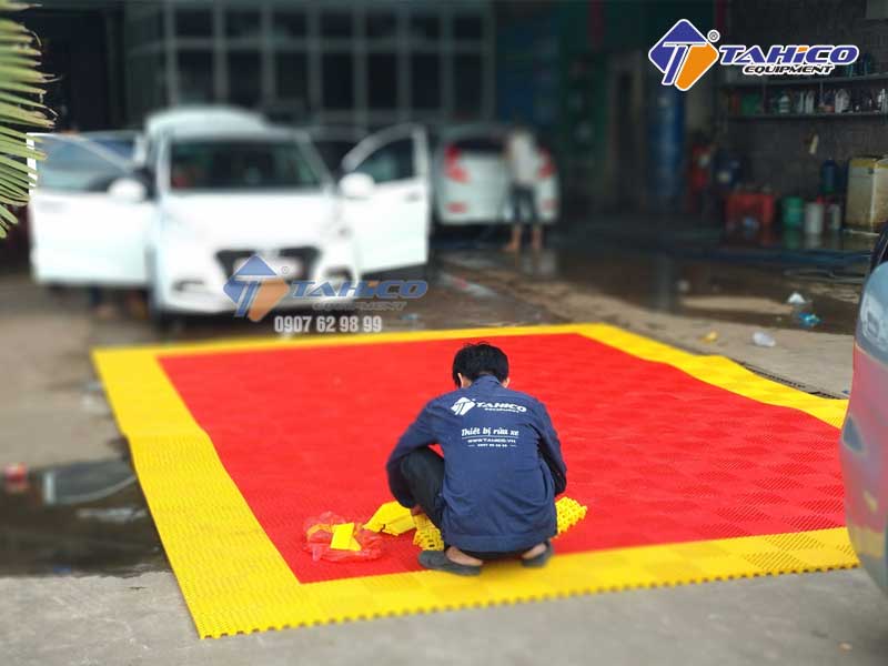 Nhân viên Tearu đang lắp đặt tấm lót sàn cho tiệm rửa xe