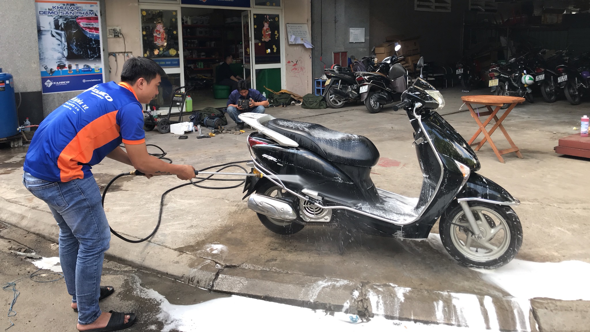 Dùng máy rửa xe cao áp xịt rửa sạch xe máy